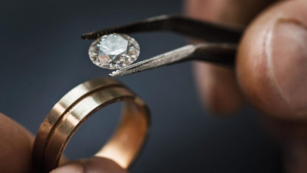 Juwelier setzt einen Diamant in einen Ring ein